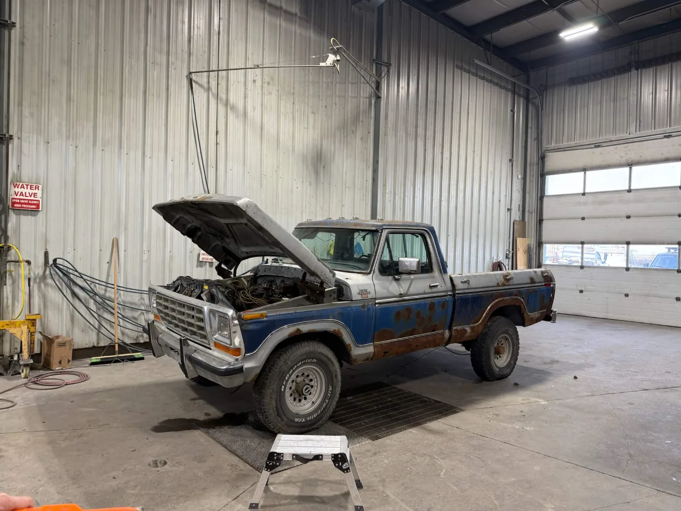 Blue and silver Ford F-Series pickup with original patina, in the shop for teardown