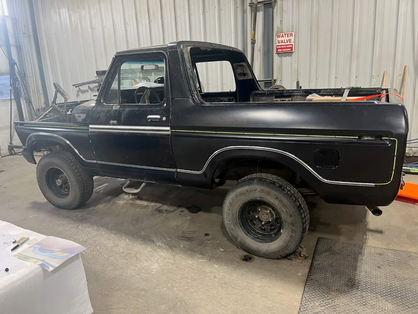 Black Ford Bronco body with the top removed, mid-build