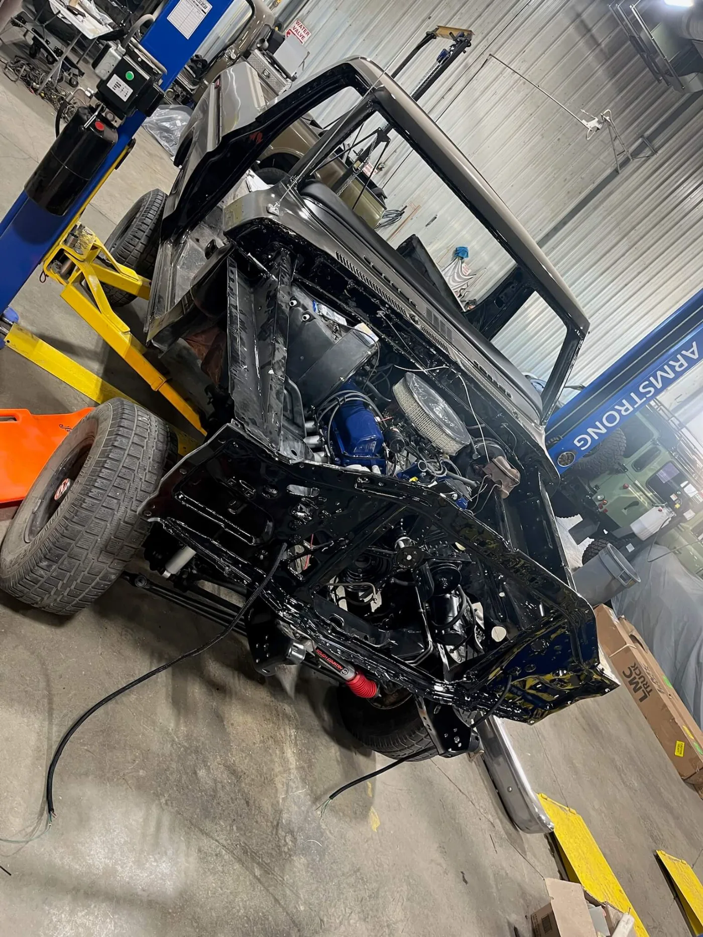 Freshly painted frame and rebuilt front suspension going back under a classic Ford truck