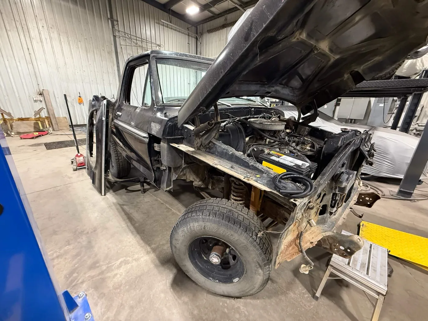 Black Ford F-Series with fenders and hood off, engine bay exposed